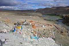 Tibet Kailash 06 Tirthapuri 11 View From Pass On Kora After the hot springs the trail climbs past a cremation area consecrated to Yeshe Tsogyal, and then reaches a miniature version of Kailash's Dlma La, marked with mani stones, prayer flags and a large collection of yak horns and skulls. To the left is the end of a recently constructed over 200m long mani wall, which points to the northeast directly towards Mount Kailas. The wall was the end result of a demon firing an arrow at the guru. He stopped the arrow's flight and transformed it into this wall.